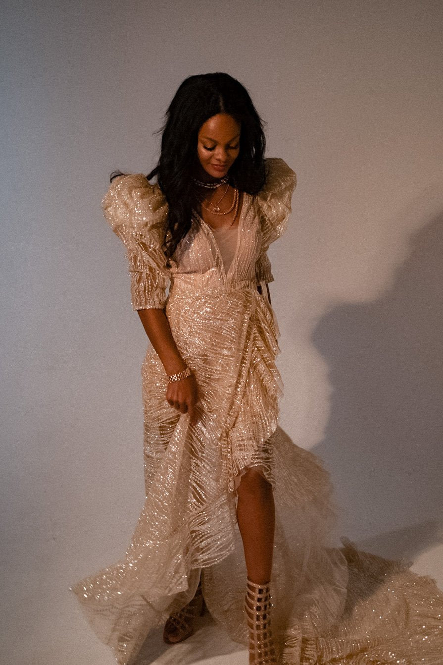 Champagne wedding dress with the removable overskirt lifted at the front over strappy sandals, soft studio light, Soleil