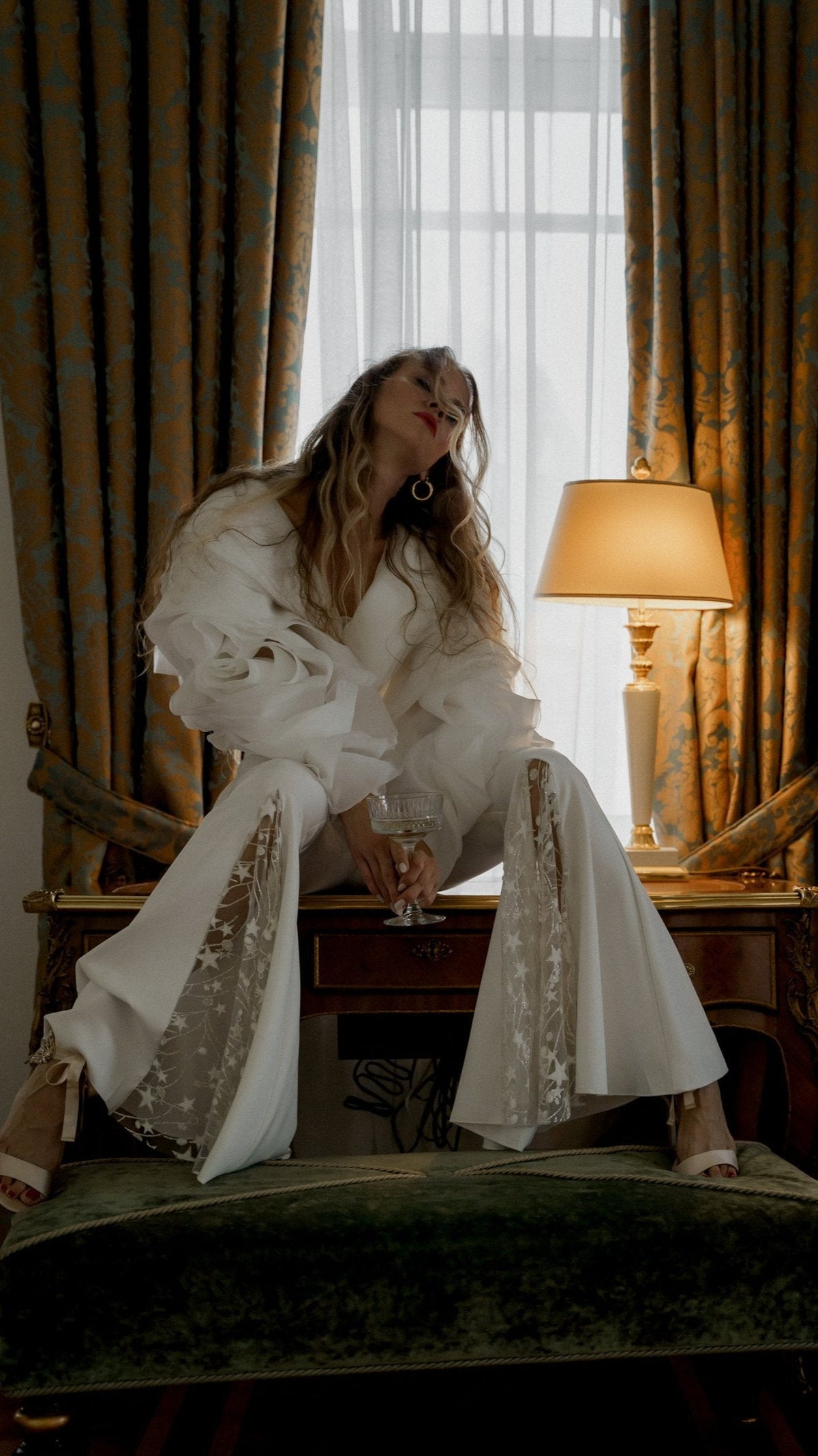 Flared bridal trousers with star lace insets, bride perched on a hotel desk in the My Darling Hurricane jacket, Sun Flares by Ephemeris