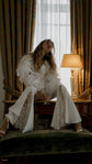 Flared bridal trousers with star lace insets, bride perched on a hotel desk in the My Darling Hurricane jacket, Sun Flares by Ephemeris