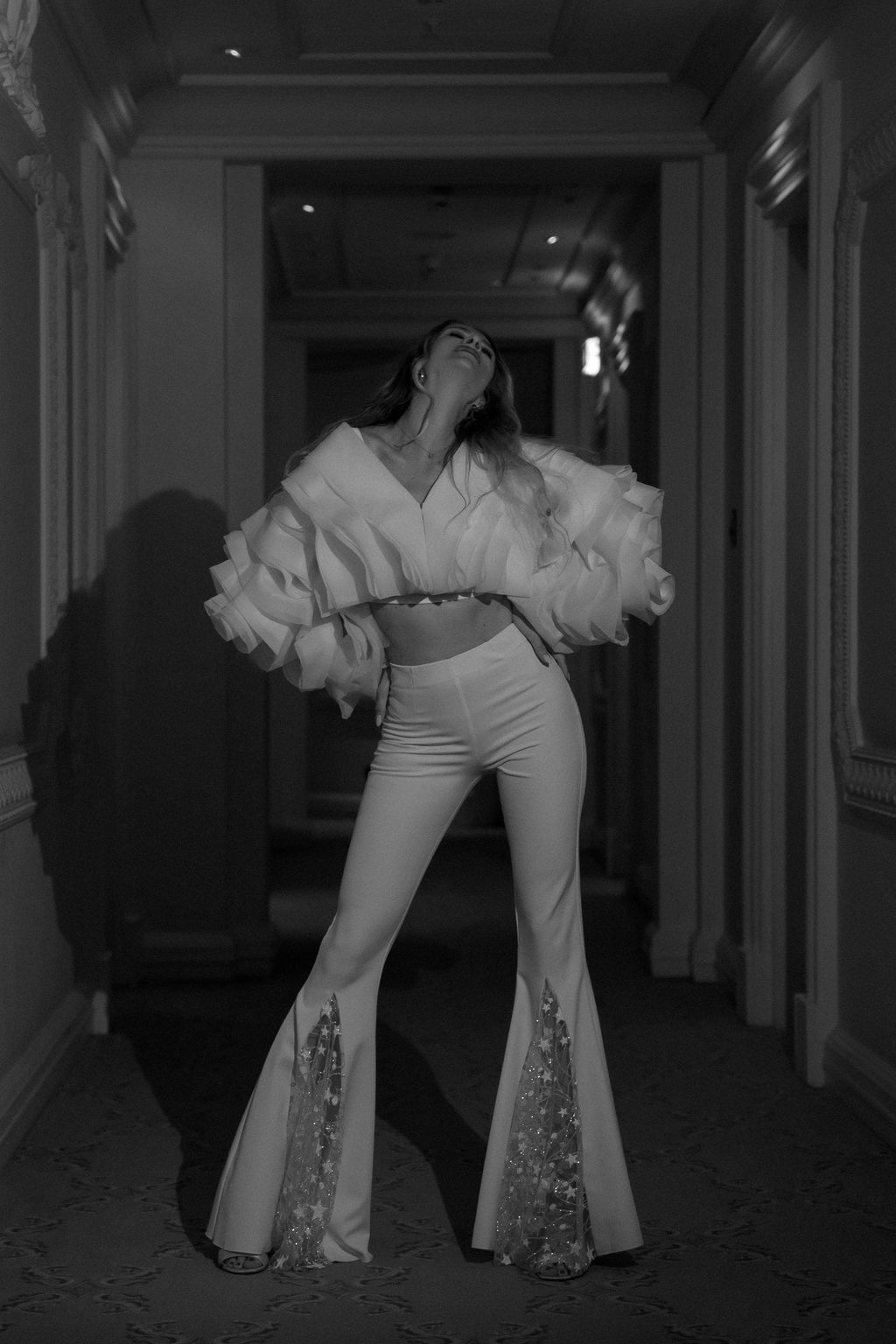 Flared bridal trousers with glittering star lace panels, bride dancing in a hotel corridor in the My Darling Hurricane jacket, Sun Flares