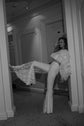 High kick showing the star lace flare of fitted bridal trousers, black and white hotel hallway shot, Sun Flares