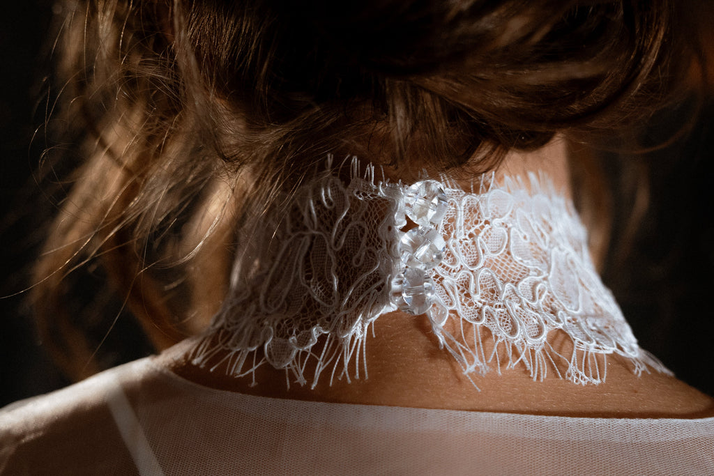 Back view of a corded lace bridal choker fastened with a row of clear bead buttons at the nape, Lyra Lace Choker