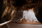 Back view of a corded lace bridal choker fastened with a row of clear bead buttons at the nape, Lyra Lace Choker
