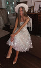 Seated model in a white hat, strapless star wedding dress with a midi tulle skirt flashing under the camera light, Wild Stars
