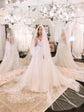 Cathedral length wedding veil spread across a rug in a mirrored bridal salon, bride under chandeliers, Cascade Veil