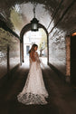 Back view of a bride walking through a brick tunnel, open back star lace wedding dress and long train, Counting Stars