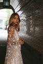 Side portrait of a bride in a tunnel, sheer star lace sleeves of a wedding dress over a slip, Counting Stars Sample