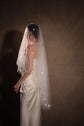 Bride turned away, two-tier star wedding veil falling down her back over a strapless satin gown in warm light, Celestial Glow Veil