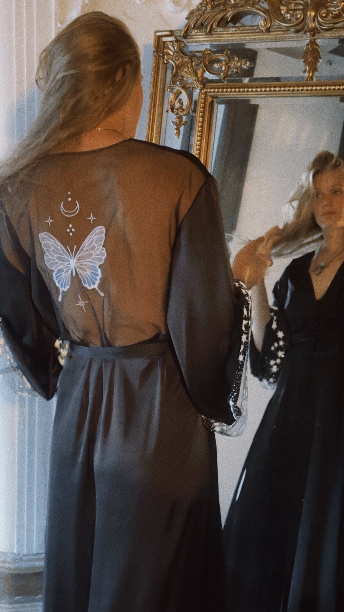 Black bridal robe with a sheer back and embroidered butterfly, bride at a gilded mirror, Metamorphosis Robe Black by Ephemeris