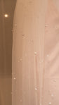 Close-up of small pearls dotted across soft tulle on a fingertip wedding veil, warm light, Pearl Whispers Veil