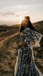 Celestial wedding dress with ivory star lace over black tulle and flutter sleeves, bride on a hillside at sunset. ASH Counting Stars by Ephemeris