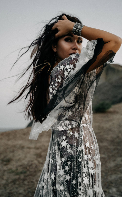 Bride with hand in her hair in a star lace wedding dress over black tulle, sheer sleeve lifted by the wind, ASH Counting Stars