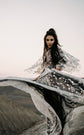 Bride twirling a star lace wedding dress skirt over black tulle on a windy hilltop, flared sleeves in motion, ASH Counting Stars