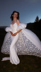Bridal cape opened at dusk to show stars glittering inside the train, worn over an ivory slip gown in a dark field, Aura Cape