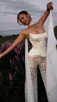 Bride lifting one end of a sheer chiffon bridal scarf overhead, satin corset and star tulle trousers among lupines, Celeste Scarf