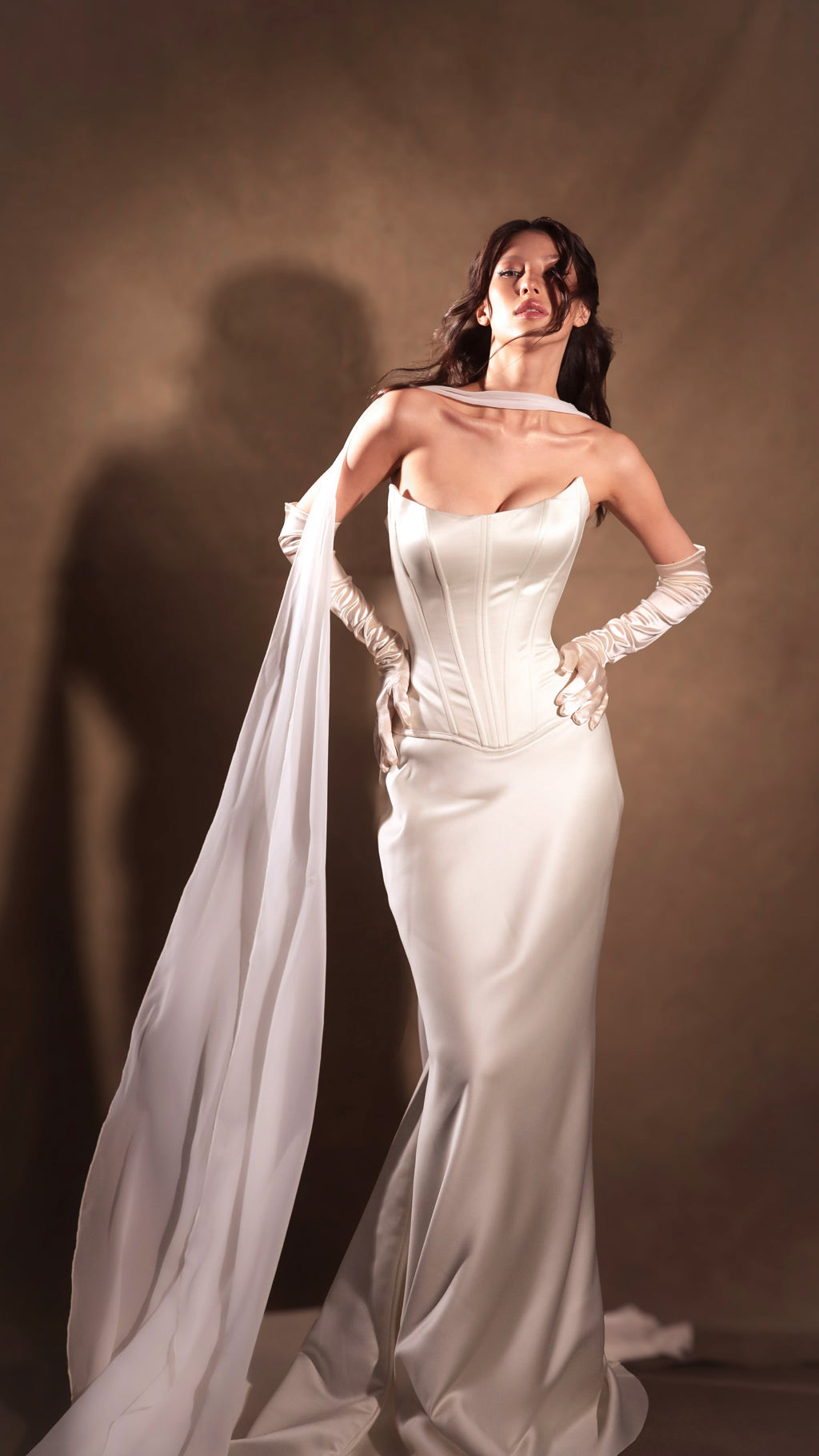 Chiffon neck scarf streaming behind a bride with hands on her hips in a satin corset gown, deep studio shadows, Celeste Scarf