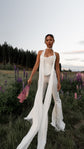 Long chiffon bridal scarf worn as a neck tie over a strapless top and flared trousers, lupines in hand at dusk, Celeste Scarf