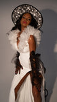 Close-up of ruffled tulle shoulders on a V-neck crepe wedding dress, model in a star-print hat and black tulle gloves, Celeste