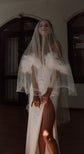 Off-shoulder crepe wedding dress with star-dotted tulle ruffles and leg slit, bride under a two-tier blusher veil, Celeste