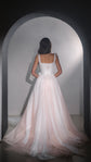 Full back view of a corset wedding dress with lace-up back and wide two-tone tulle skirt, model facing an arch, Chrysanthemum