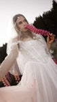 Bride holding a pink lupine to her face under a starry tulle hood, blush corset wedding dress, Chrysanthemum