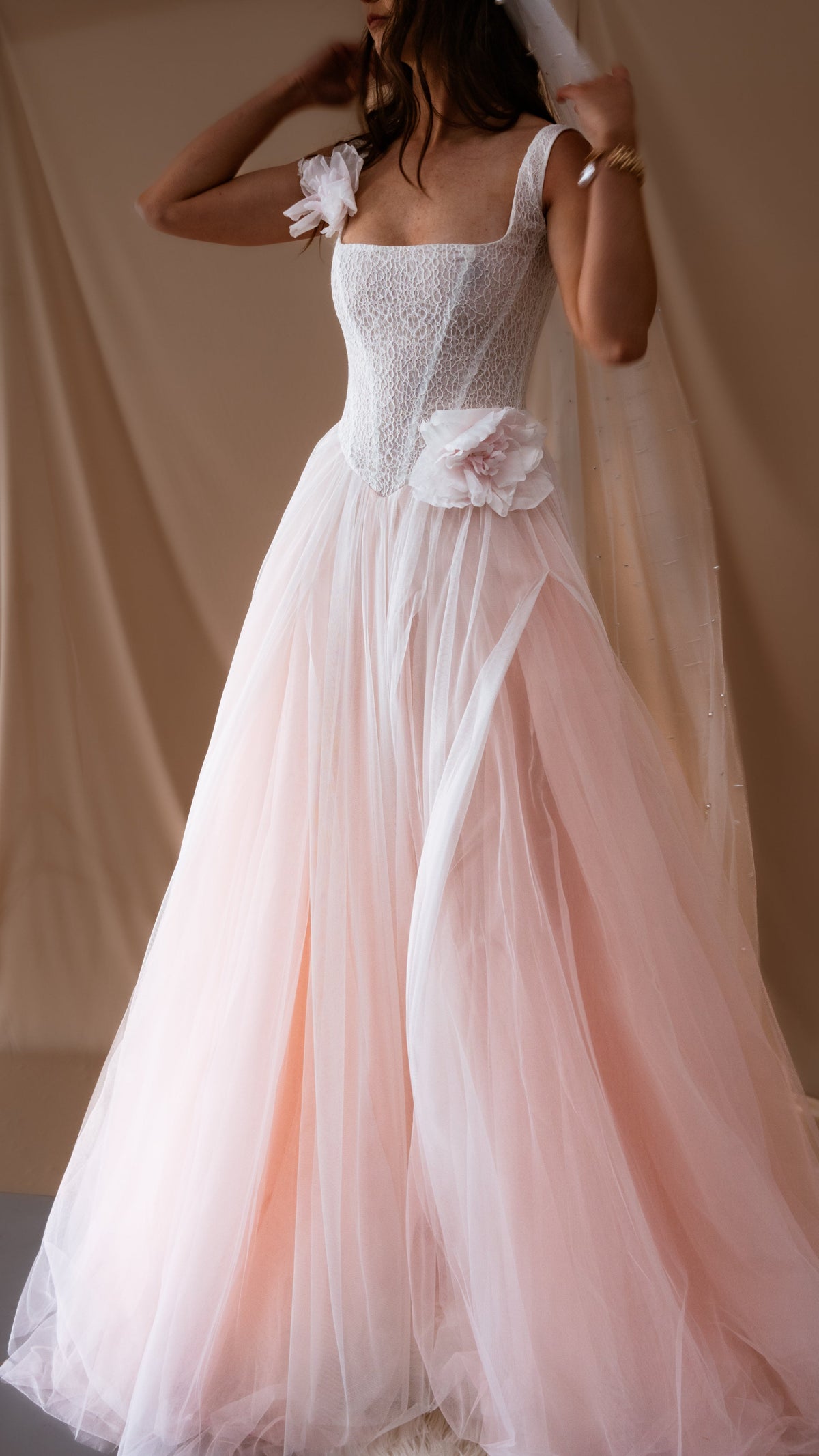 Full-length blush wedding dress with square neckline, dropped corset bodice and full two-tone tulle skirt, warm studio drape, Chrysanthemum