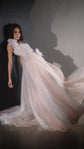 Model leaning back against a wall, blush tulle skirt of a corset wedding dress sweeping out across the floor, Chrysanthemum