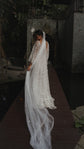 Back view of a cathedral star wedding veil trailing along a wooden boardwalk in a dark garden, star lace gown, Coastal Moonlight Veil