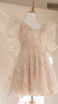 Star lace mini wedding dress with puff sleeves and blush lining on a dress form, full skirt and fitted waist, Cosmic Dancer