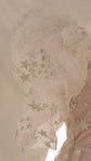 Close-up of a sheer puff sleeve in glittering star lace on a short wedding dress, soft studio light, Cosmic Dancer