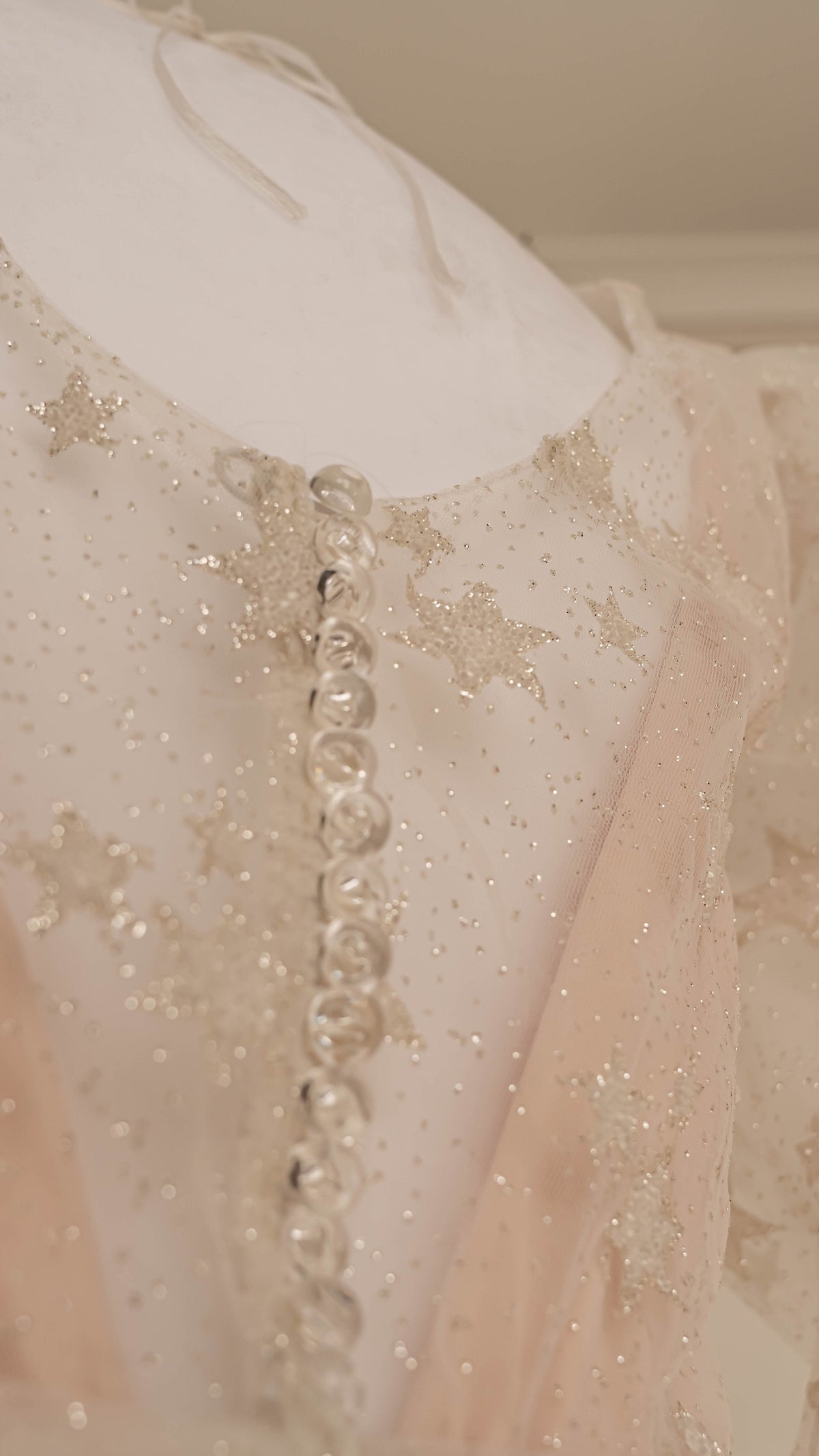 Back detail of a star lace mini wedding dress with a row of covered buttons and glitter tulle, Cosmic Dancer