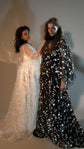 Two models side by side, an ivory and a black star lace wedding dress with flowing sheer sleeves, studio, Counting Stars 2.0