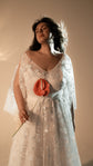 Bride with eyes closed holding a red anthurium, V-neck star lace wedding dress with sheer sleeves, Counting Stars 2.0