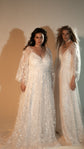 Two models in ivory star lace wedding dresses with long sheer sleeves, front view in warm studio light, Counting Stars 2.0