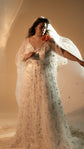 Bride holding a red flower and a flowing tulle veil, star lace wedding dress with cape sleeves, Counting Stars 2.0
