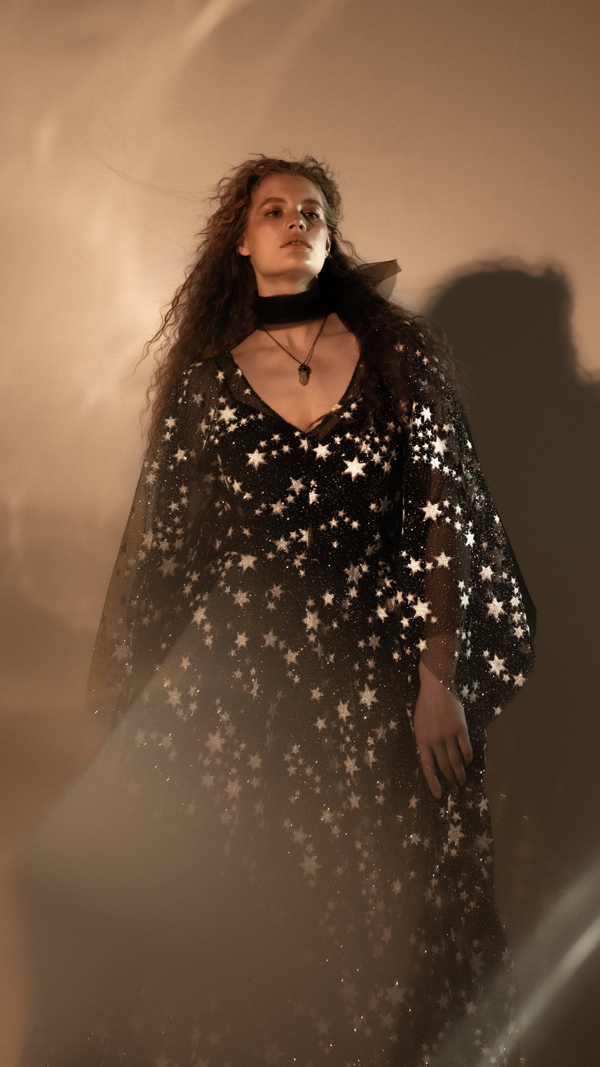 Alt bride in a black star lace wedding dress with sheer cape sleeves and a black ribbon choker, Counting Stars Black