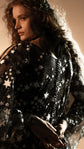 Close-up of the shoulder and bodice of a black gothic wedding dress covered in glittering star lace, Counting Stars Black