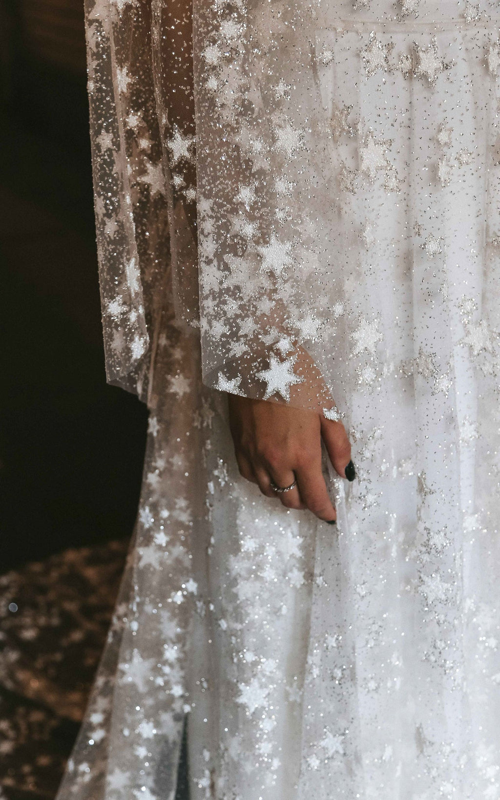 Close-up of glittering stars on the sheer sleeve and skirt of a lace wedding dress, Counting Stars Sample