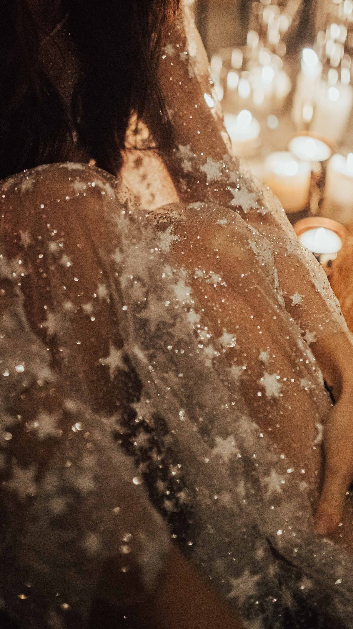 Close-up of sparkling star lace on the shoulder of a wedding dress, candles glowing behind, Counting Stars Sample
