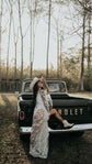 Bride resting one boot on a pickup tailgate in a cowboy hat, sheer star lace wedding dress, Counting Stars Sample