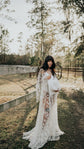 Bride holding a white hat by a ranch fence, sheer star lace wedding dress with bell sleeves and train, Counting Stars Sample