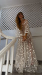 Celestial wedding dress in starry lace with sheer bell sleeves over a satin slip, smiling bride on a white staircase. Counting Stars by Ephemeris