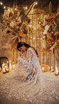 Bride seated among candles and dried flowers, star lace wedding dress and long sleeves pooled around her, Counting Stars