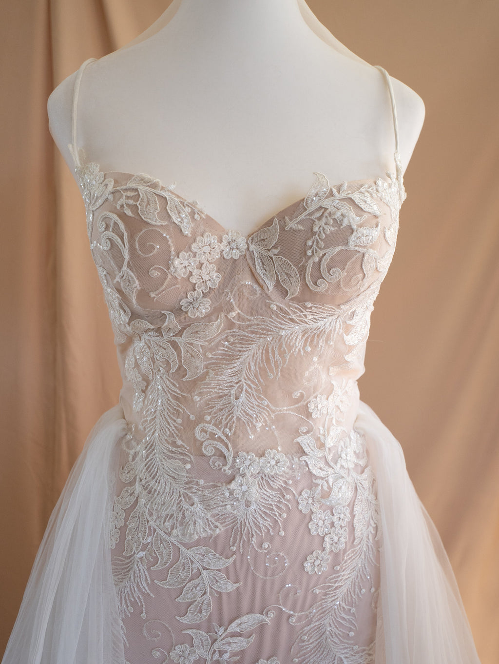Dress form close-up of a corded lace sweetheart bodice with thin straps and tulle overskirt, Feathers Sample