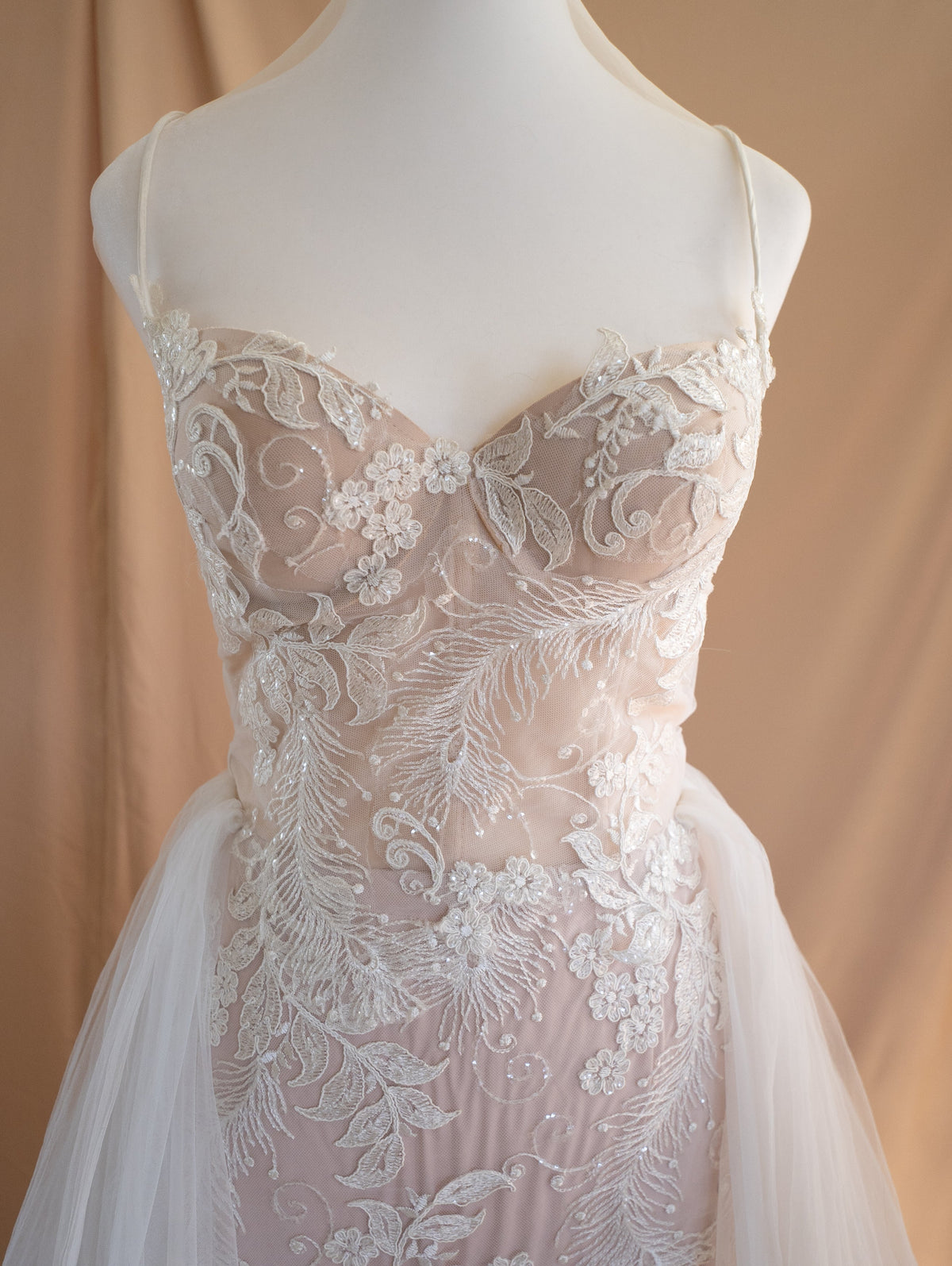 Dress form close-up of a corded lace sweetheart bodice with thin straps and tulle overskirt, Feathers Sample