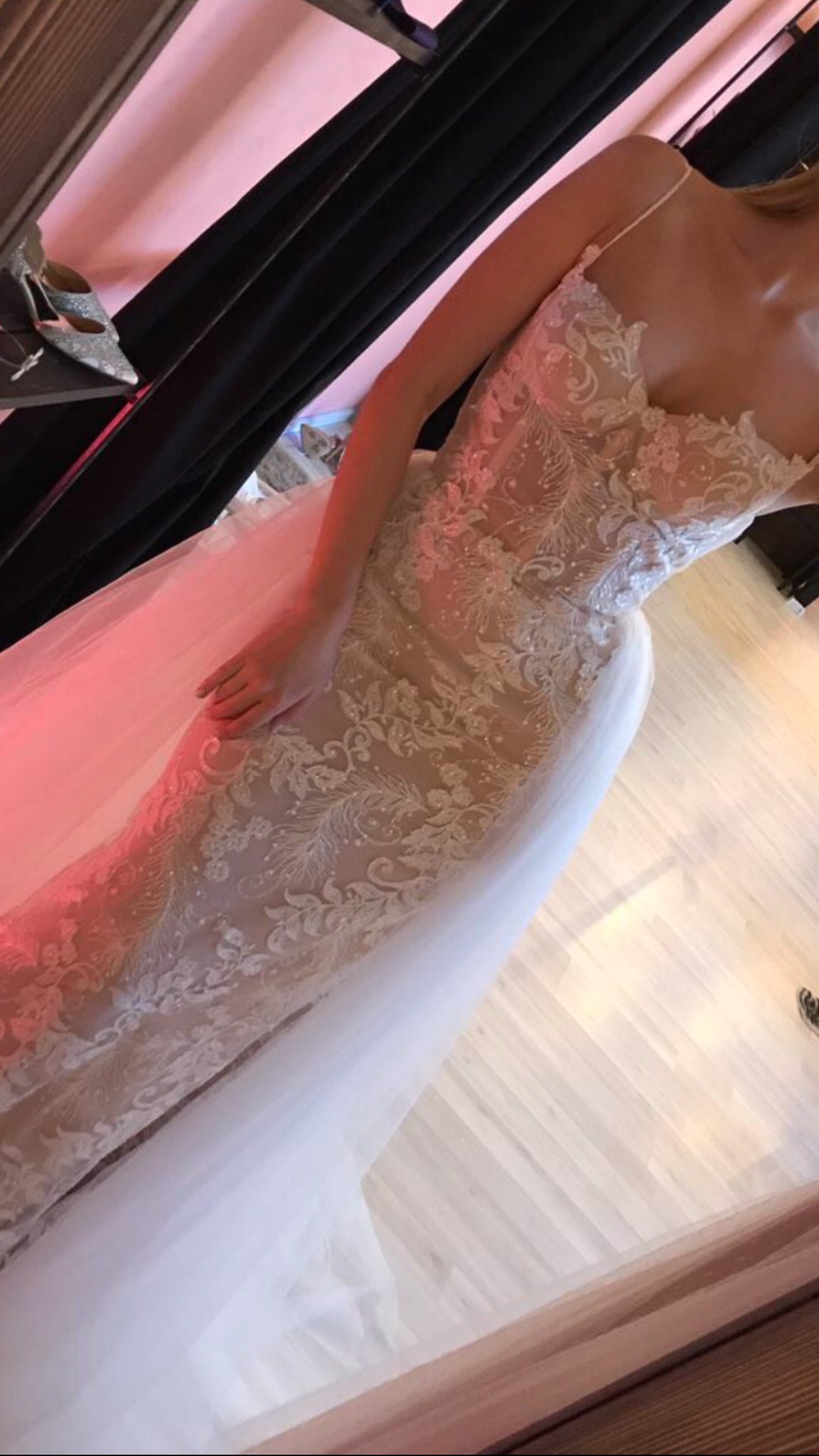 Mirror shot looking down at a corded lace wedding dress bodice and tulle skirt in pink light, Feathers Sample