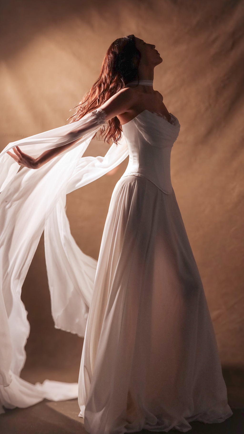 Bride arching back with arms out, long chiffon bridal sleeves flowing to the floor from a strapless corset gown, FEYRE Sleeves
