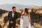 Groom leading the bride by the hand, fitted silk wedding dress with off-shoulder chiffon sleeves and a leg slit, FEYRE