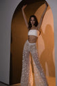 Model with arms raised in an arched studio, full-length star lace wedding pants with flared wide legs, Galactic Outlaw