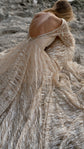 Over-the-shoulder crop of a scooped open back on a champagne glitter lace wedding dress, skirt pooled on rock, Galaxy Champagne